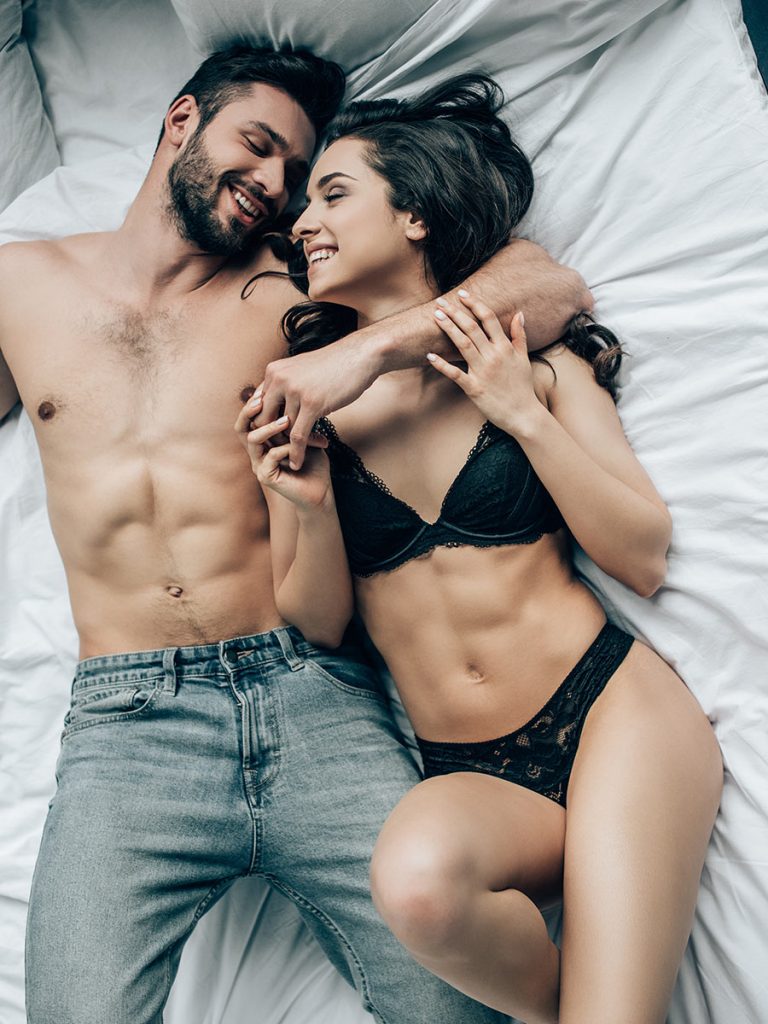 Attractive couple enjoys their casual romance in bed